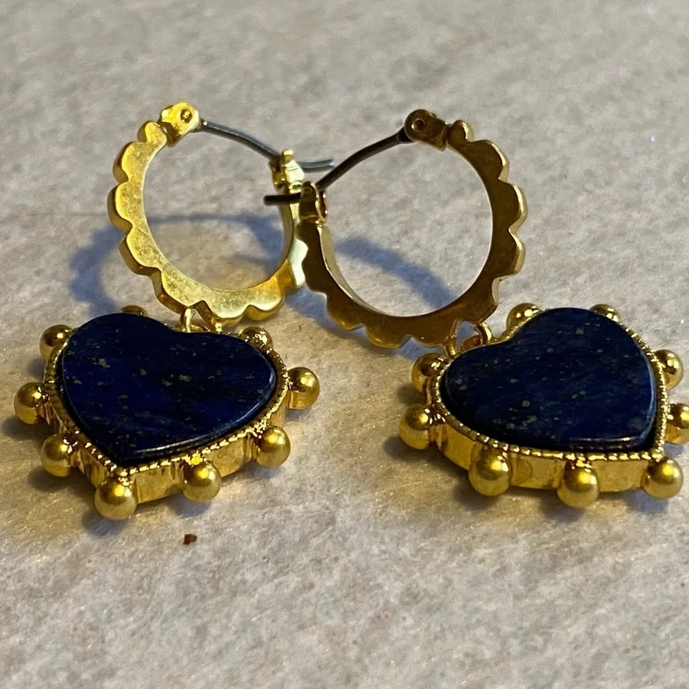 Tory Burch blue lapis heart drops hanging from huggie hoops.
